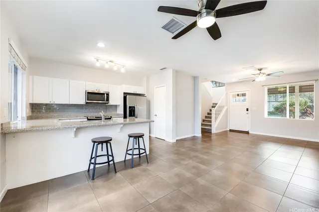 a view of kitchen with stainless steel appliances wooden floor and window