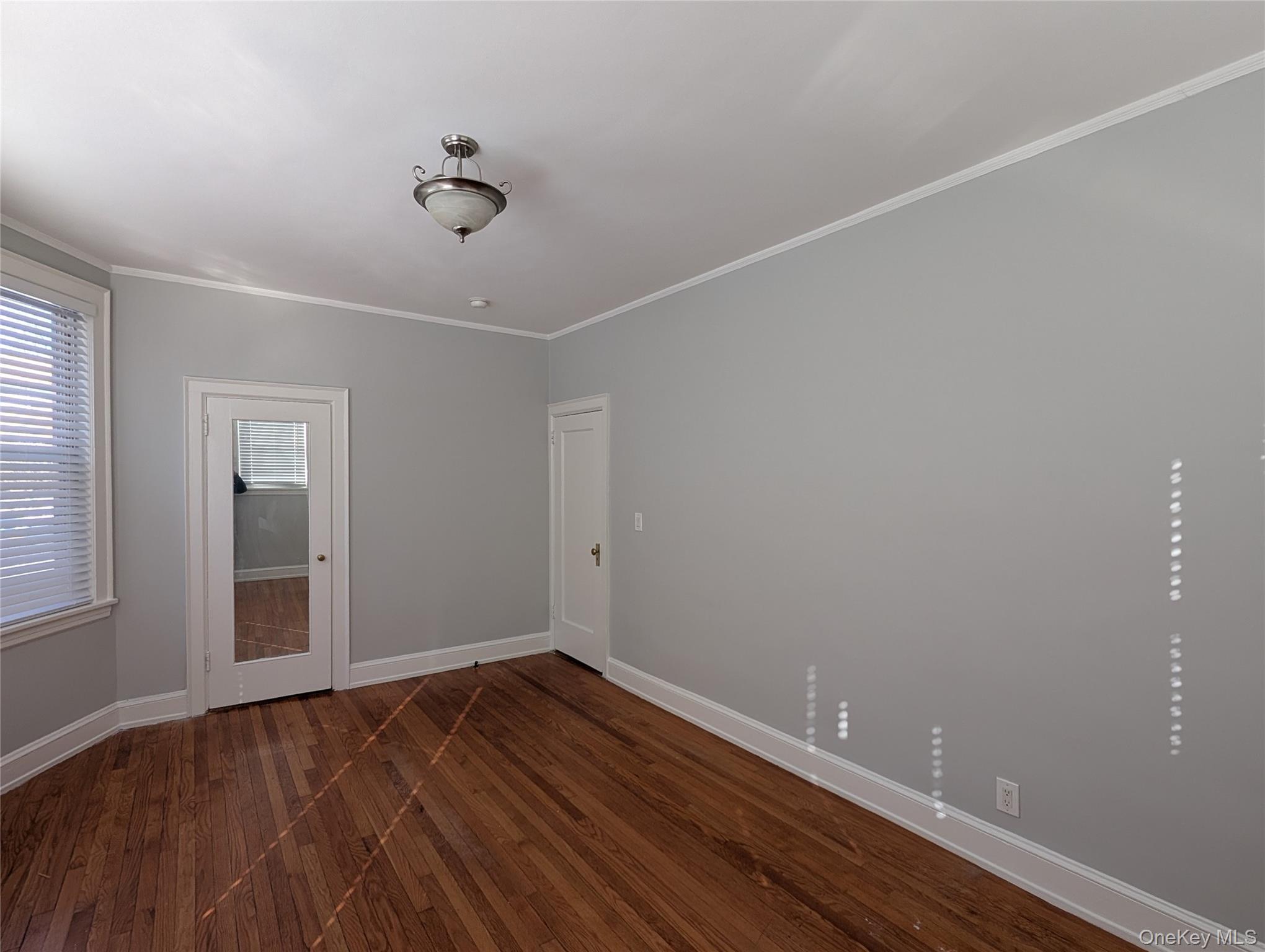 26 Coligni Avenue, Unit 12 New Rochelle, NY 10801 - Photo 12 of 18 wooden floor in an empty room with a window