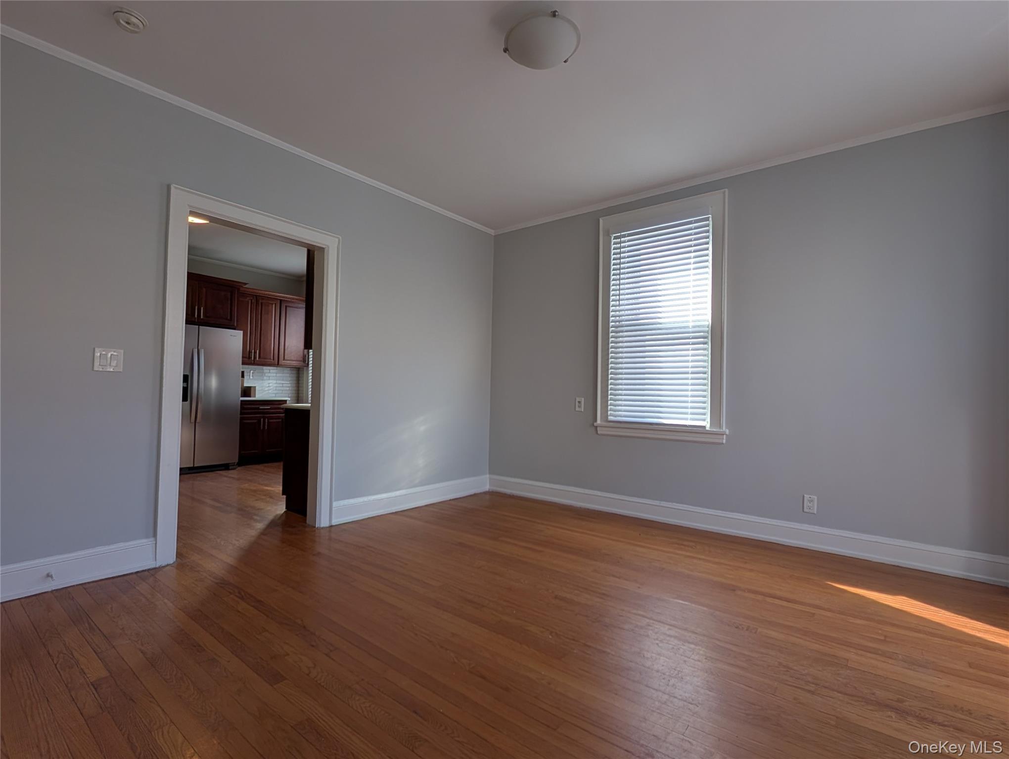 26 Coligni Avenue, Unit 12 New Rochelle, NY 10801 - Photo 4 of 18 a view of an empty room with wooden floor and a window