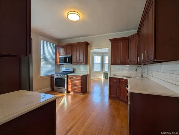 a kitchen with granite countertop a stove top oven a sink a counter space and cabinets