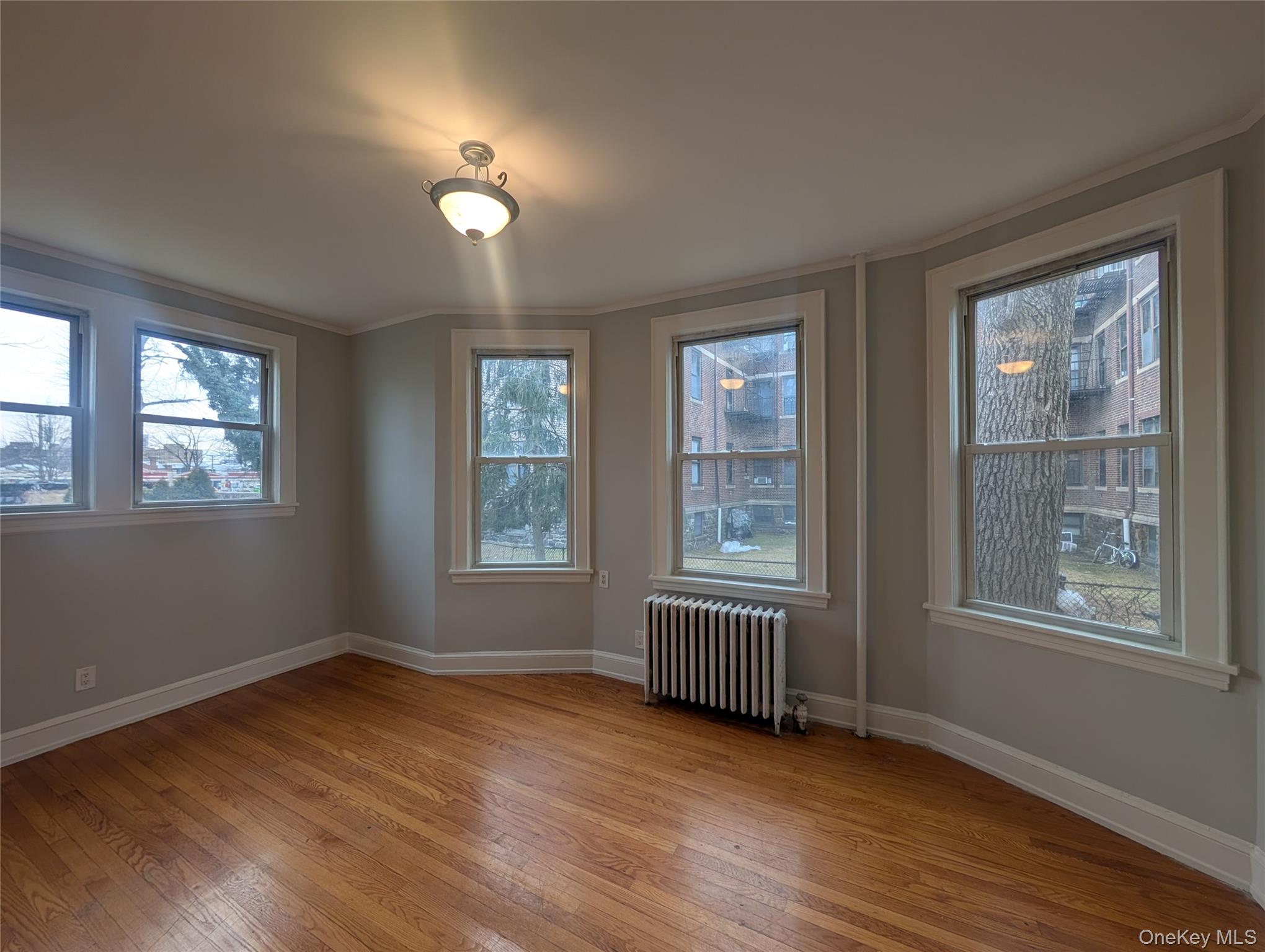 26 Coligni Avenue, Unit 12 New Rochelle, NY 10801 - Photo 10 of 18 a view of an empty room with wooden floor and a window
