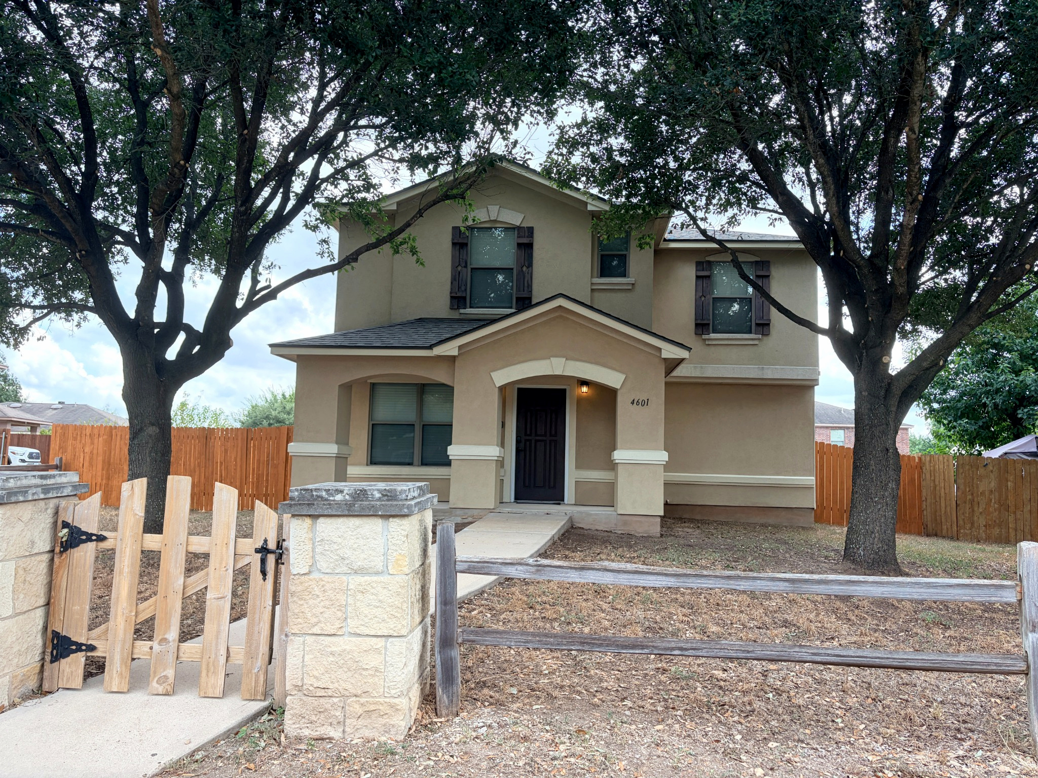 4601 Nuckols Crossing Road Austin, TX 78744 - Photo 1 of 18 Mature trees frame the stucco facade and covered entryway of this classic two-story residence.