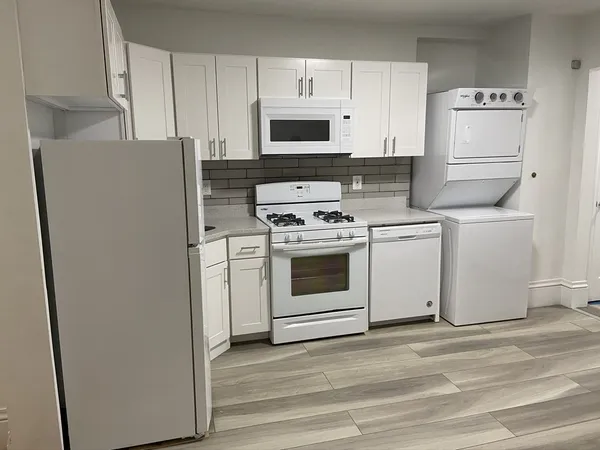 a kitchen with white cabinets and white appliances