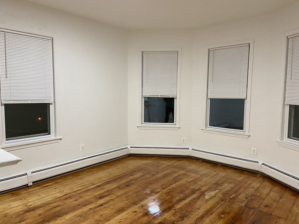 252 Windsor Street, Unit 3 Cambridge, MA 02139 - Photo 11 of 21 a view of an empty room with wooden floor and a window
