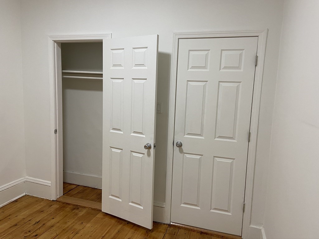 252 Windsor Street, Unit 3 Cambridge, MA 02139 - Photo 14 of 21 an empty room with wooden floor and closet