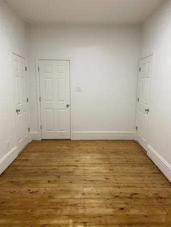 a view of empty room with wooden floor