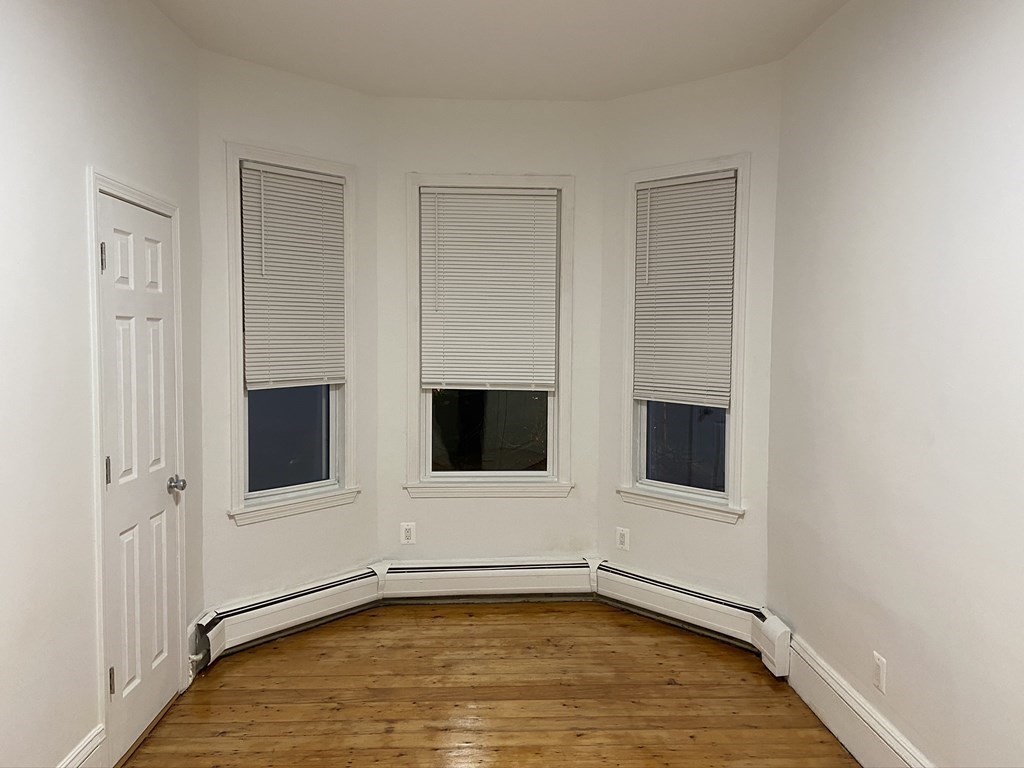 252 Windsor Street, Unit 3 Cambridge, MA 02139 - Photo 17 of 21 a view of an empty room with wooden floor and cabinet