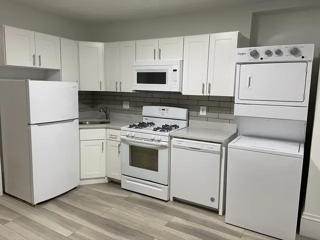 a kitchen with white cabinets and white appliances