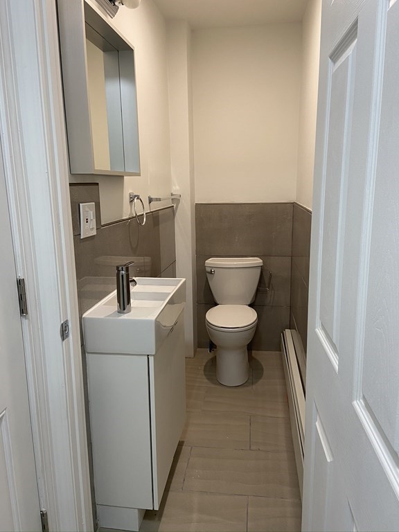 252 Windsor Street, Unit 3 Cambridge, MA 02139 - Photo 8 of 21 a bathroom with a toilet sink and mirror