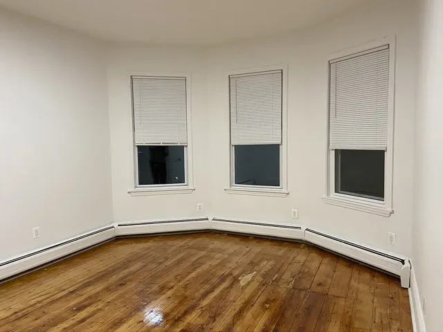 a view of a room with wooden floor and flat screen tv