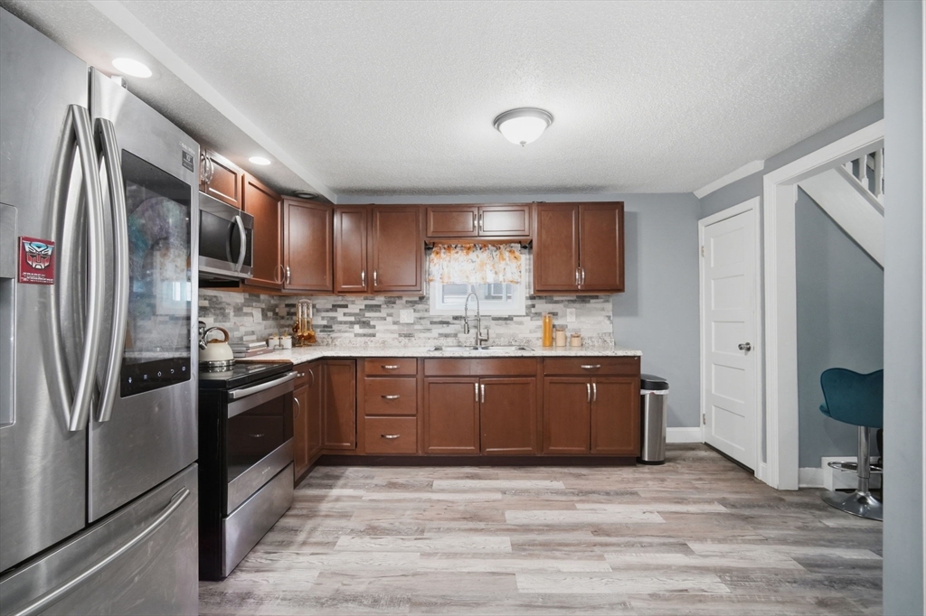 72 Switzer Avenue Springfield, MA 01109 - Photo 8 of 37 a kitchen with stainless steel appliances granite countertop a refrigerator stove and oven