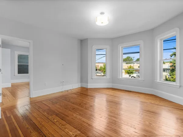an empty room with window and wooden floor