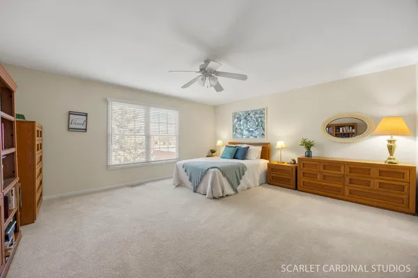 a spacious bedroom with a bed and a dresser