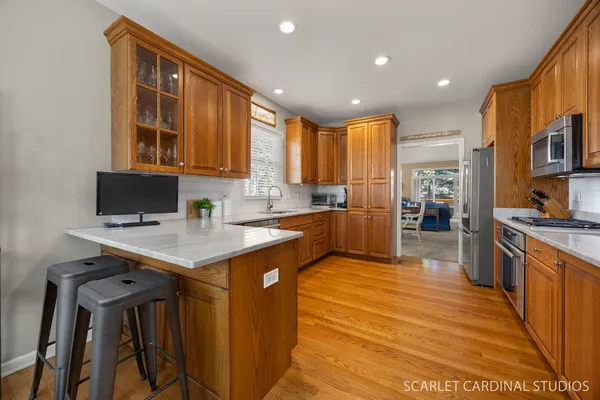 a kitchen with stainless steel appliances granite countertop a stove top oven a sink and a refrigerator