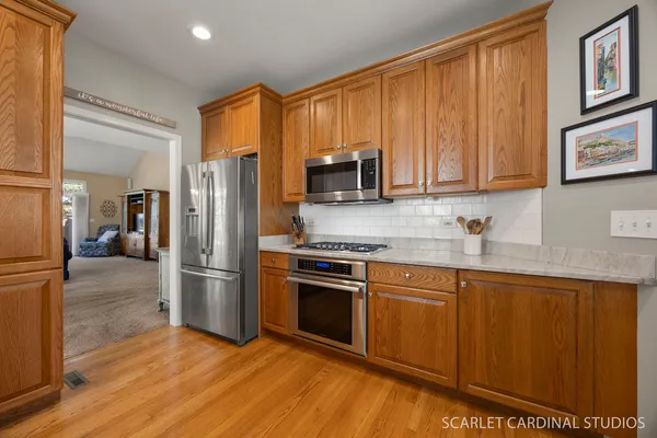 a kitchen with stainless steel appliances granite countertop a refrigerator stove top oven and sink
