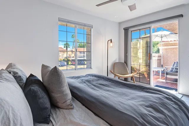 a bedroom with a bed a chair and glass door