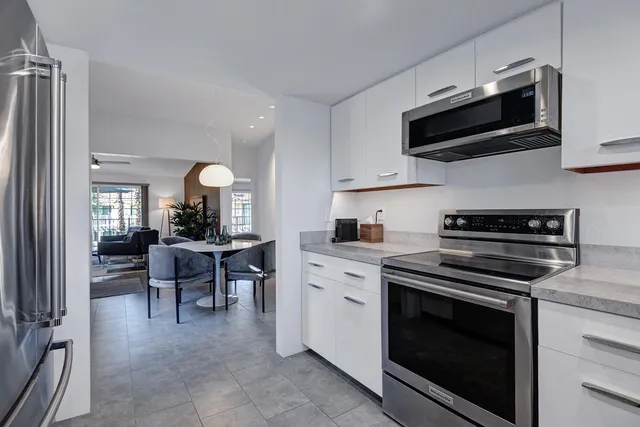 a kitchen with stainless steel appliances granite countertop a refrigerator sink and stove