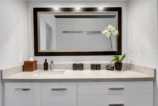 a bathroom with a sink vanity and mirror