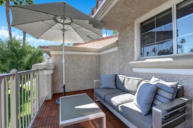 a view of balcony with furniture and umbrella