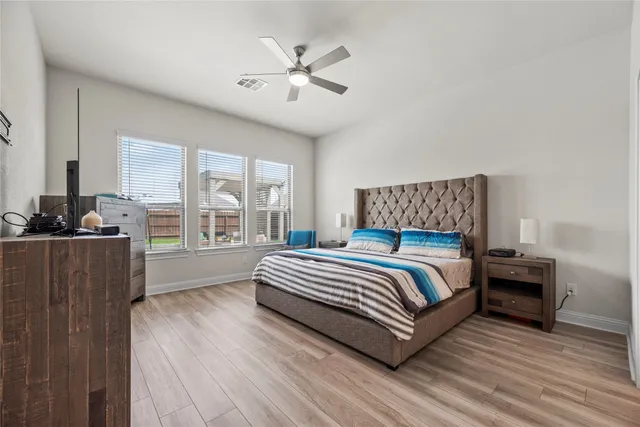 a bed sitting in a bedroom next to a window with a chandelier