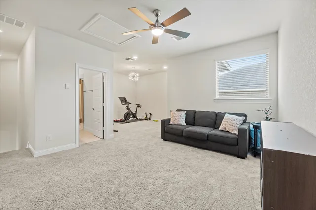 a living room with furniture and a ceiling fan