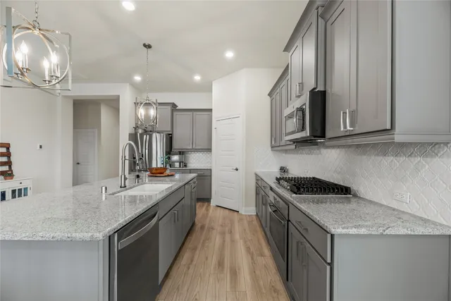a kitchen with stainless steel appliances granite countertop a sink and stove
