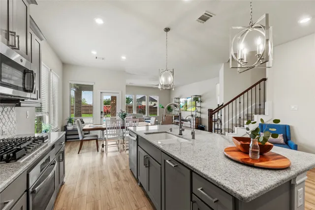 a kitchen with sink stove and cabinets