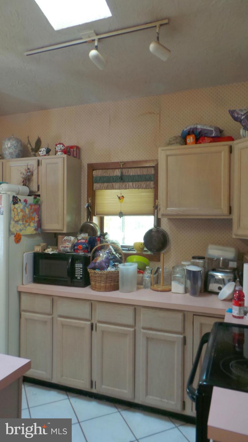 318 Dorchester Road Pasadena, MD 21122 - Photo 5 of 11 a kitchen with cabinets a window and appliances