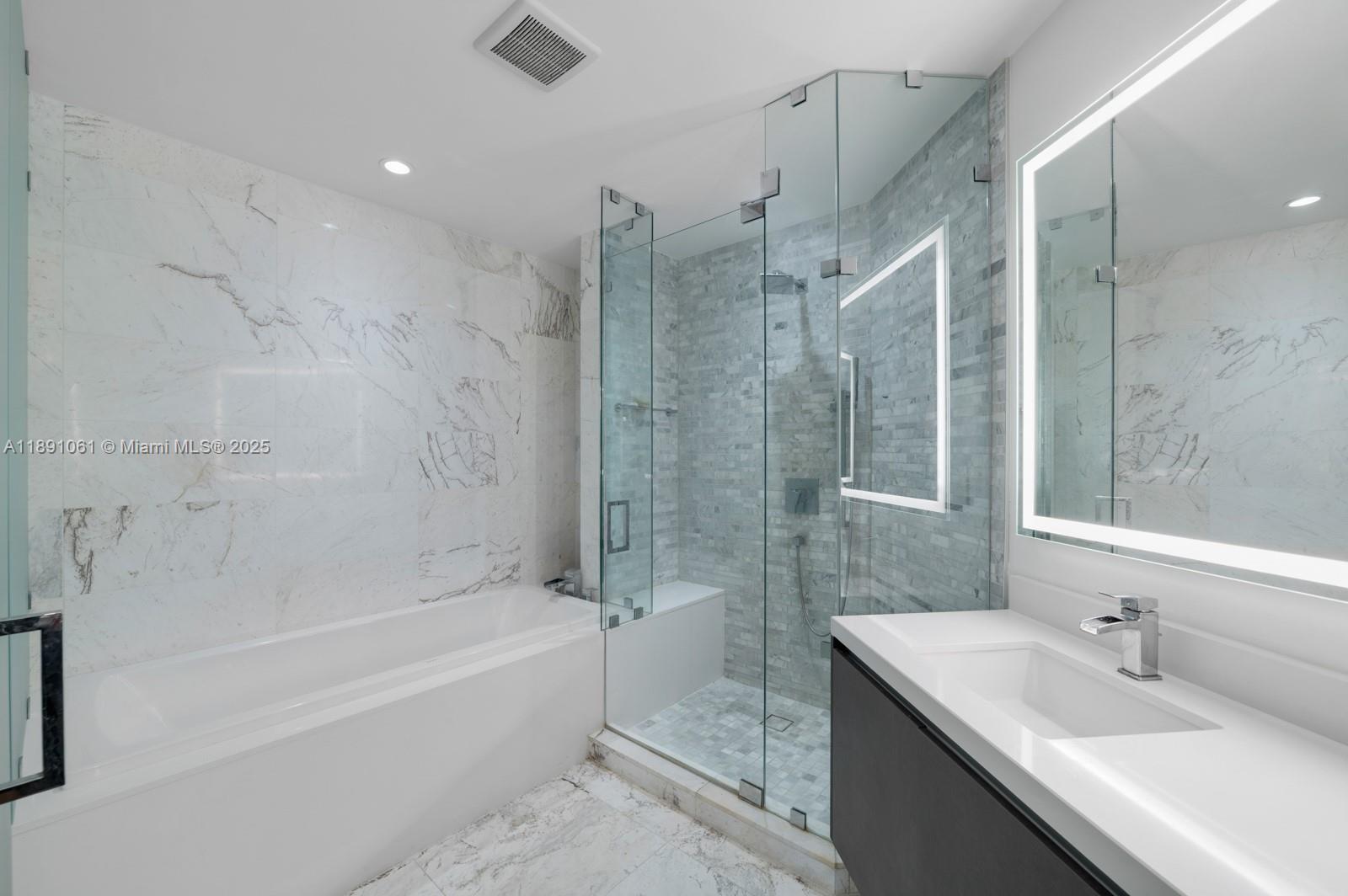 851 Northeast 1st Avenue, Unit 4403 Miami, FL 33132 - Photo 10 of 31 a bathroom with a sink double vanity granite tub and shower