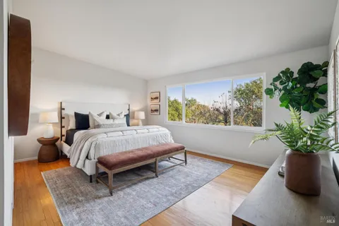 a bed sitting in a spacious bedroom next to a window