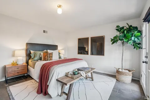 a bedroom with a bed lamp and a potted plant