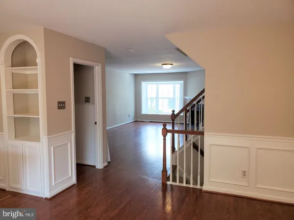 a view of hallway with stairs and wooden floor