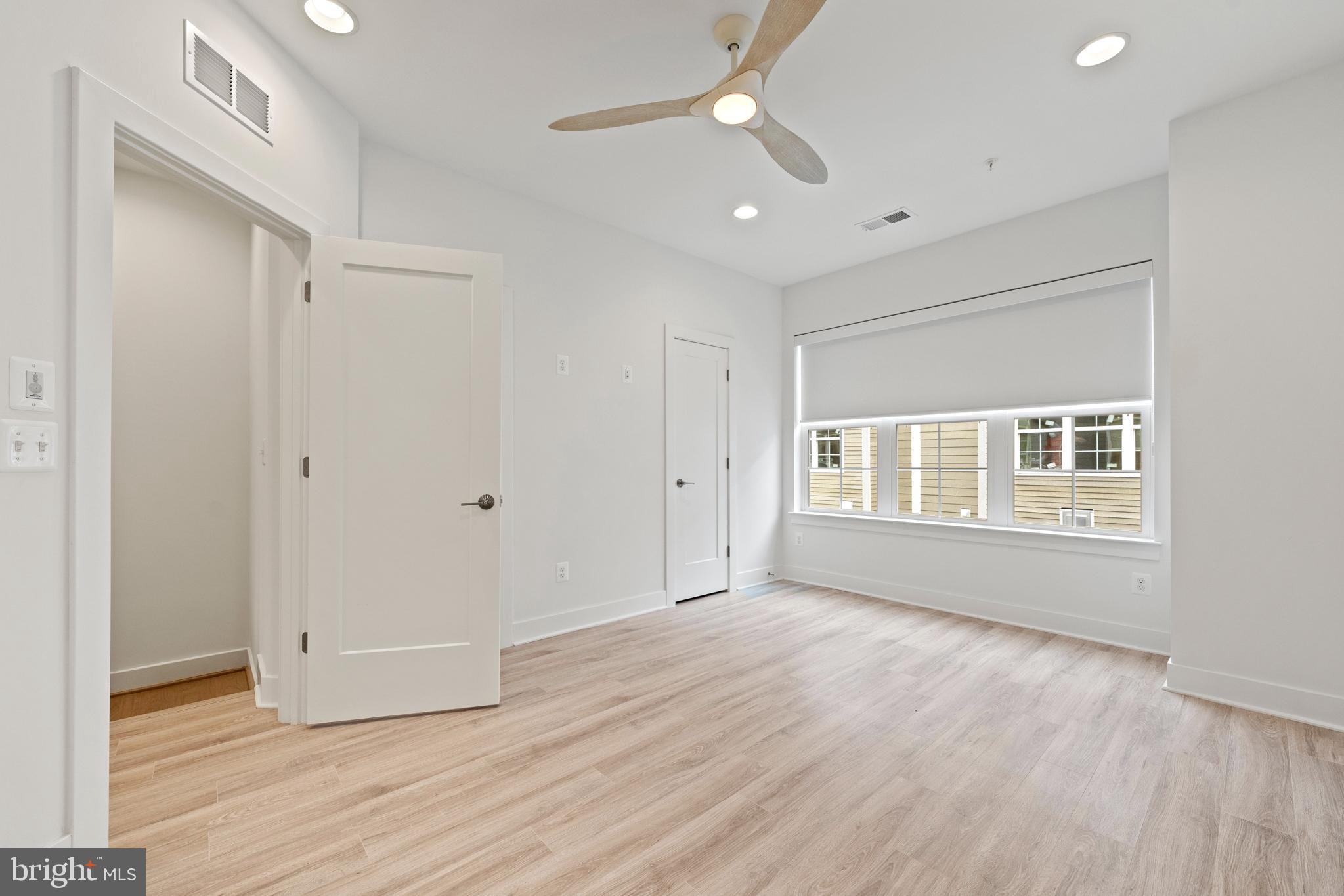 11249 Beaker Street Reston, VA 20190 - Photo 12 of 32 a view of an empty room with wooden floor and a window