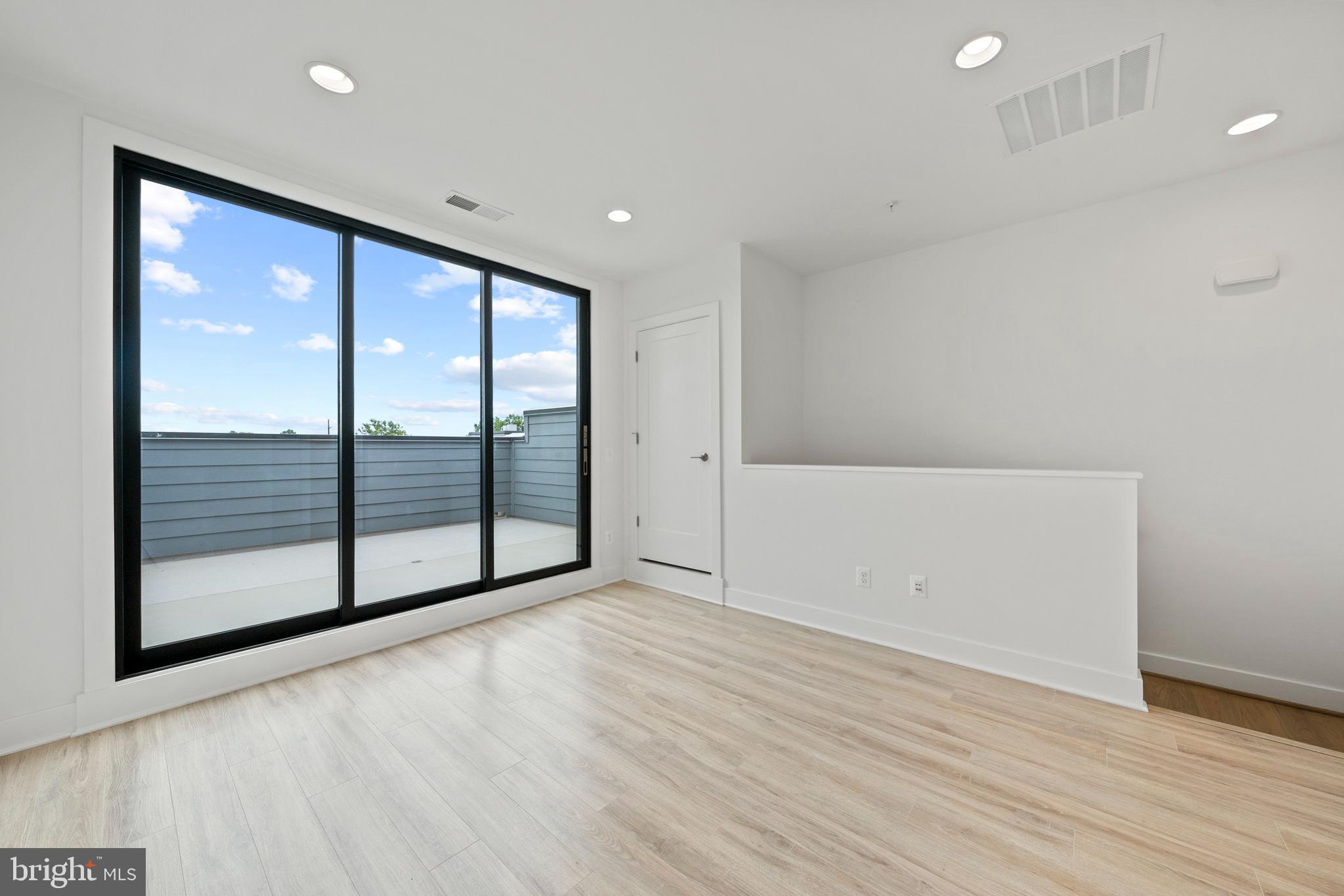 11249 Beaker Street Reston, VA 20190 - Photo 22 of 32 a view of an empty room with wooden floor and a window