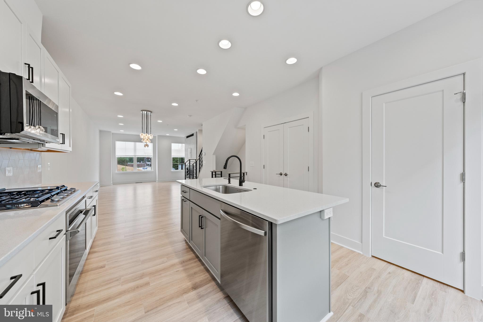 11249 Beaker Street Reston, VA 20190 - Photo 6 of 32 a kitchen with a sink stove and wooden floor