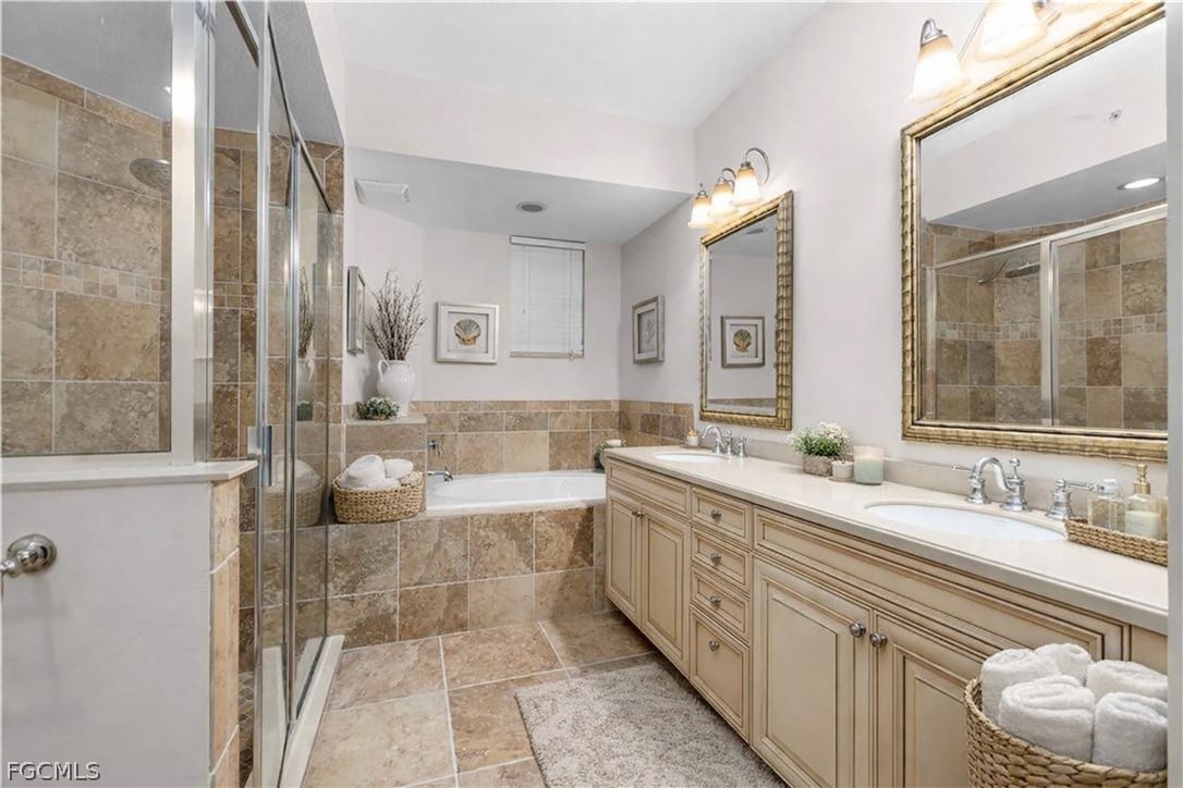 13110 Pebblebrook Point Circle, Unit 102 Fort Myers, FL 33905 - Photo 13 of 35 a spacious bathroom with a bathtub sink and mirror