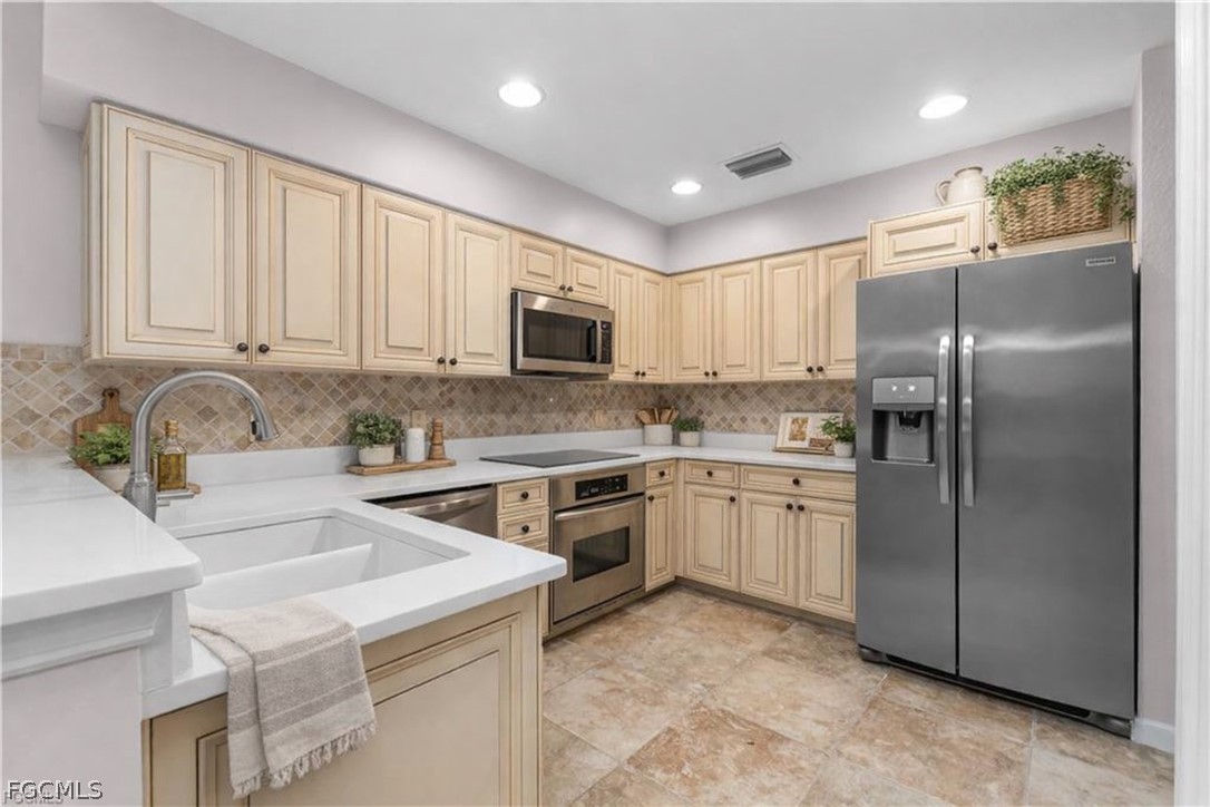 13110 Pebblebrook Point Circle, Unit 102 Fort Myers, FL 33905 - Photo 9 of 35 a kitchen with kitchen island a counter top space cabinets and stainless steel appliances