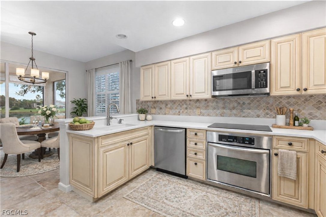 13110 Pebblebrook Point Circle, Unit 102 Fort Myers, FL 33905 - Photo 10 of 35 a kitchen with a stove and a microwave