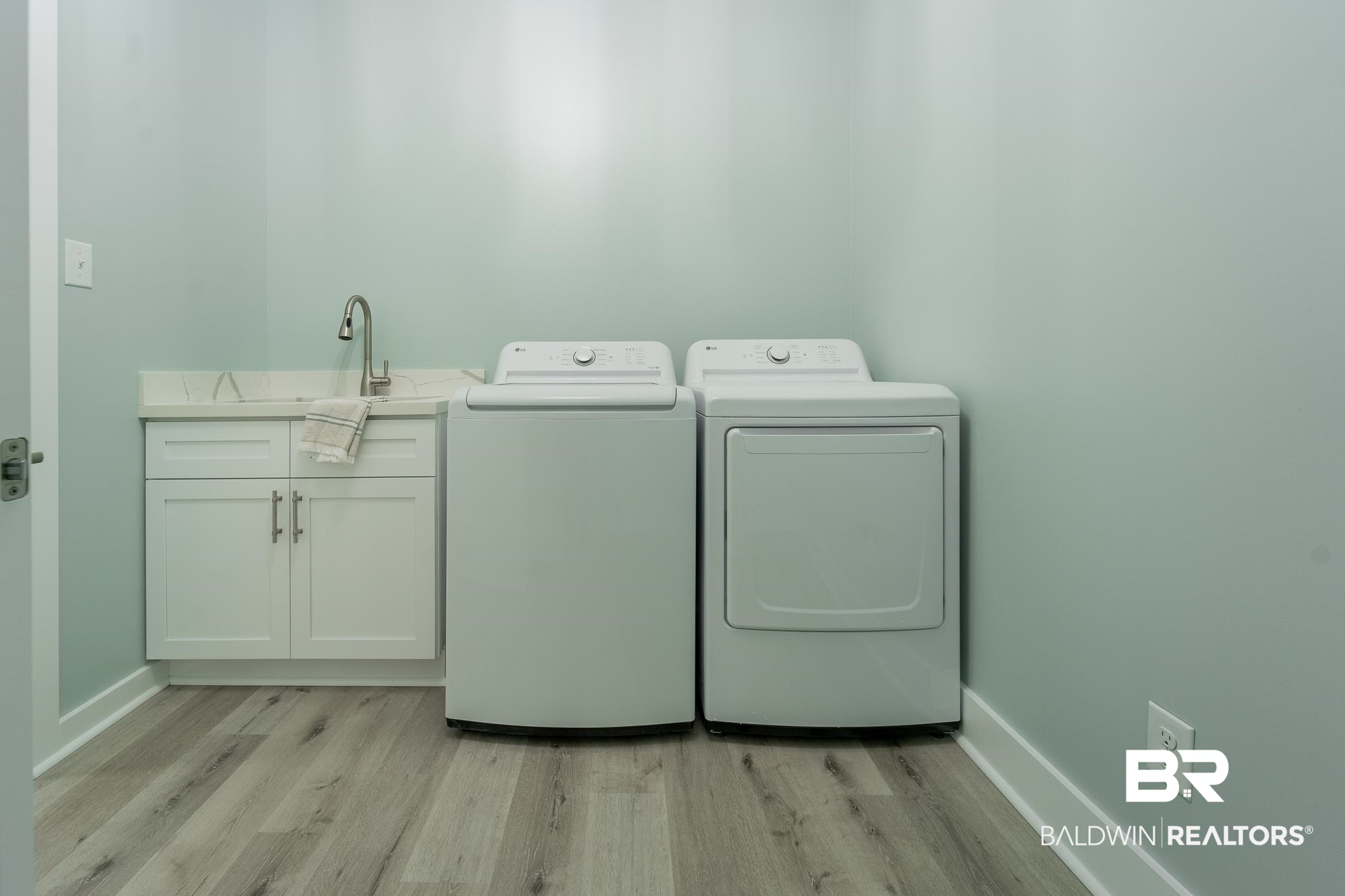 9263 Clarke Ridge Road Foley, AL 36535 - Photo 20 of 40 Laundry area with cabinets, light hardwood / wood-style floors, washer and clothes dryer, and sink