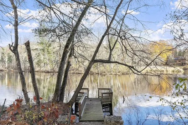 a backyard of a house with lots of green space and lake view