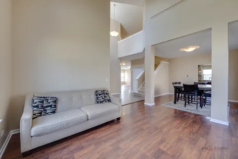 an empty room with wooden floor fireplace and windows