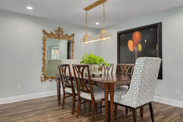 a dining room with furniture potted plants and wooden floor