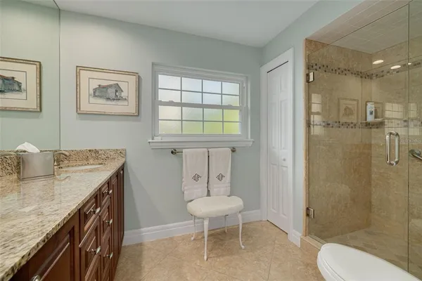 a bathroom with a granite countertop sink toilet a mirror and shower