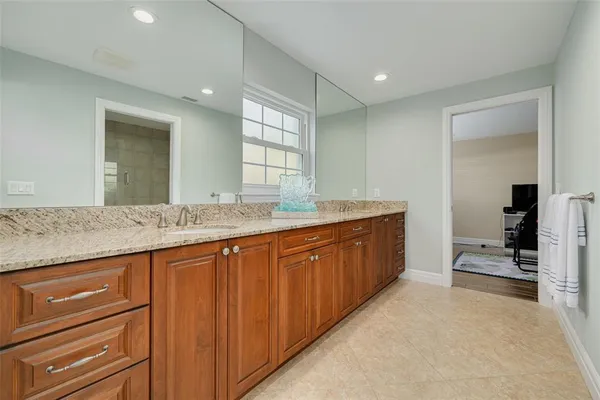 a bathroom with a granite countertop sink and a mirror