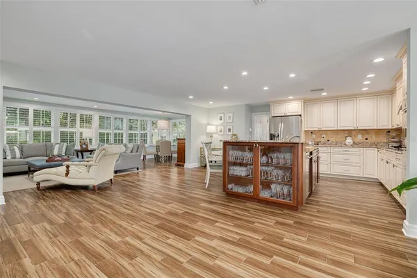 a living room with furniture and kitchen view with wooden floor