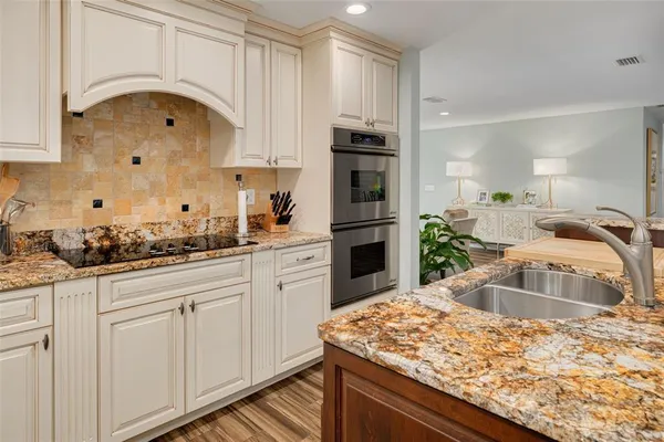 a kitchen with stainless steel appliances granite countertop a sink stove and cabinets