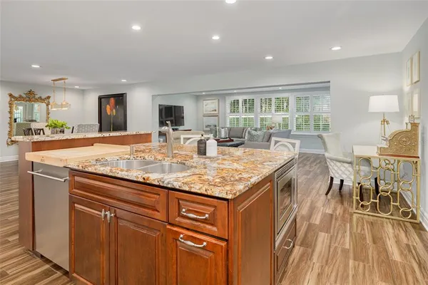 a kitchen with granite countertop kitchen island wooden floor and stainless steel appliances