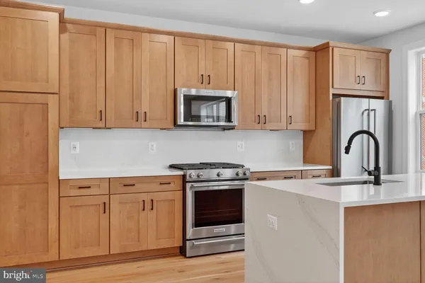 a kitchen with granite countertop white cabinets and stainless steel appliances