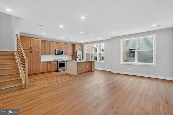 a view of a kitchen with wooden floor and electronic appliances