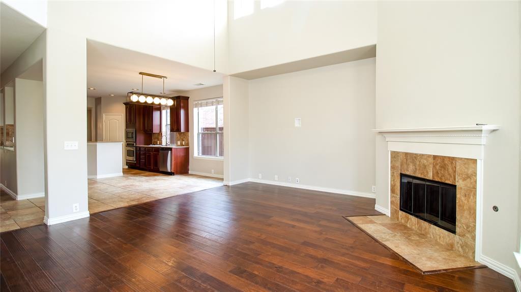 8698 Fisher Road Frisco, TX 75033 - Photo 12 of 33 a view of empty room with wooden floor and fireplace